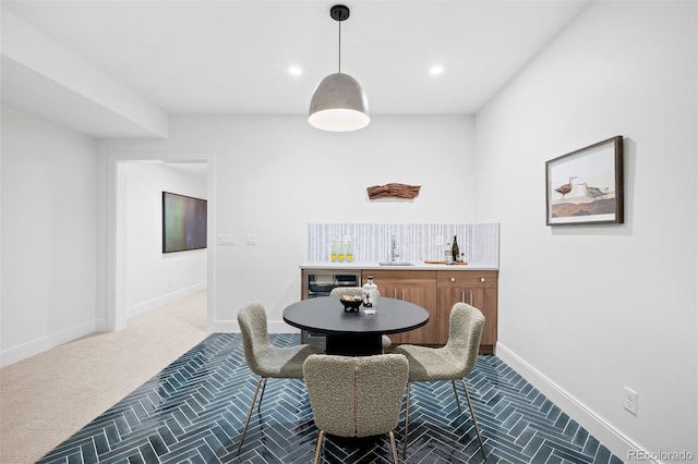 dining area featuring carpet flooring, beverage cooler, and sink