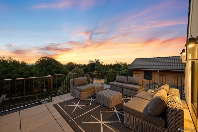 patio terrace at dusk with outdoor lounge area and a balcony