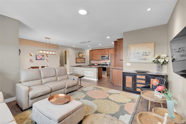 living room with sink, hardwood / wood-style floors, and an inviting chandelier