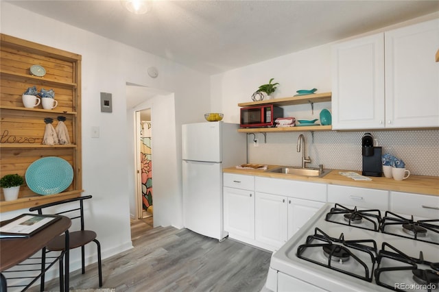 517 Canon Ave, Manitou Springs, CO 80829 - kitchen with white appliances, tasteful backsplash, wood finished floors, white cabinets, and light countertops