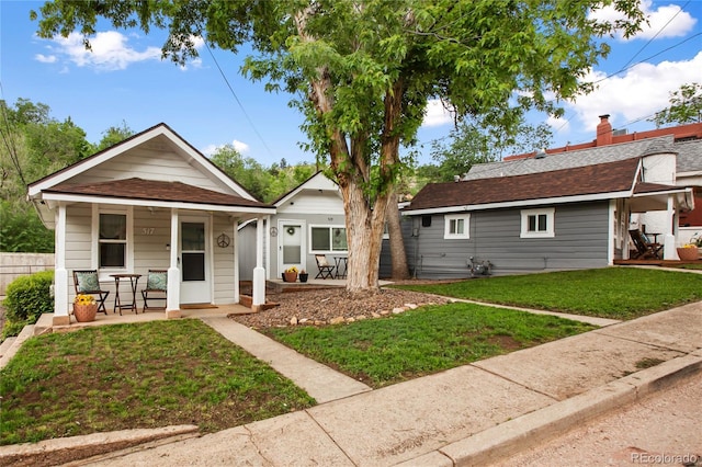 517 Canon Ave, Manitou Springs, CO 80829 - view of front of home featuring covered porch, a front lawn, and a shingled roof