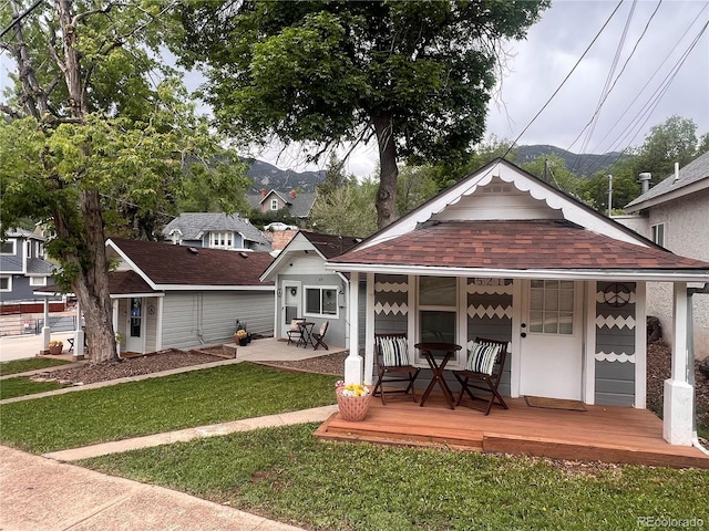 517 Canon Ave, Manitou Springs, CO 80829 - view of front of property with a front yard, a shingled roof, and a porch