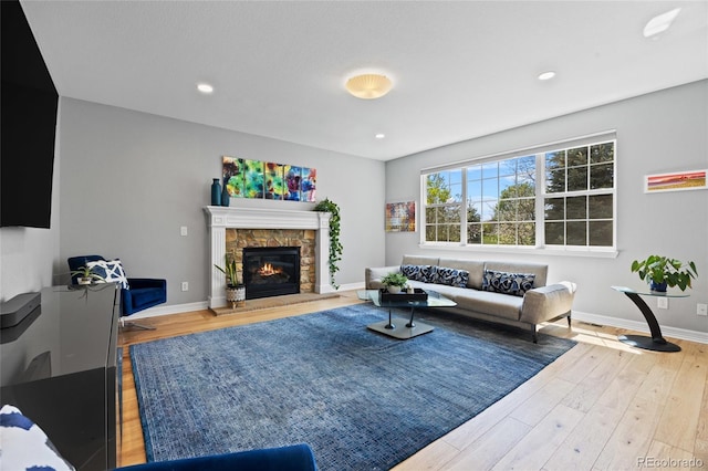 living area with a fireplace, recessed lighting, baseboards, and wood finished floors