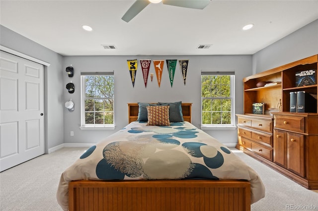 bedroom featuring light colored carpet, baseboards, ceiling fan, and visible vents