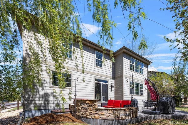 back of property featuring a patio and an outdoor living space