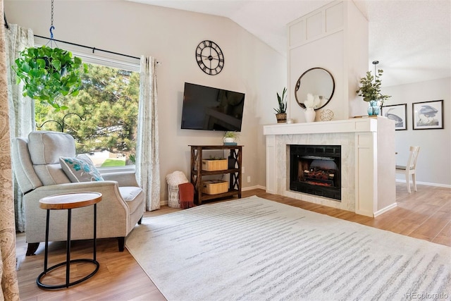 7 Shetland Ct, Highlands Ranch, CO 80130 - living area featuring wood finished floors, lofted ceiling, a tiled fireplace, and baseboards