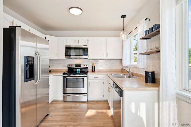 7 Shetland Ct, Highlands Ranch, CO 80130 - kitchen with appliances with stainless steel finishes, a sink, open shelves, light wood-style flooring, and tasteful backsplash