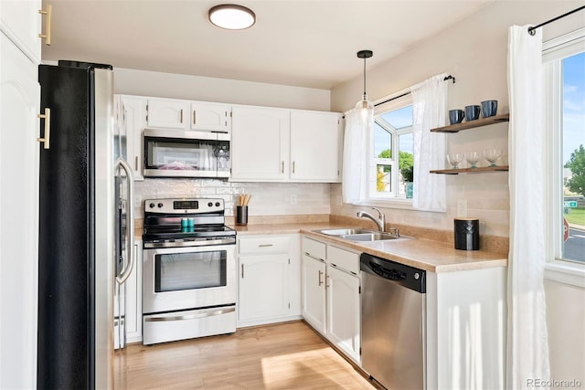 7 Shetland Ct, Highlands Ranch, CO 80130 - kitchen with stainless steel appliances, a sink, light countertops, white cabinetry, and tasteful backsplash