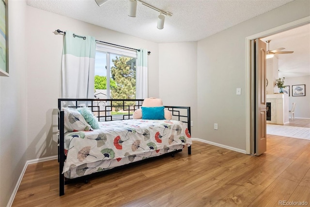 7 Shetland Ct, Highlands Ranch, CO 80130 - bedroom featuring light wood-style floors, a textured ceiling, baseboards, track lighting, and a ceiling fan