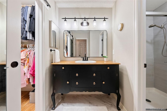 7 Shetland Ct, Highlands Ranch, CO 80130 - bathroom with vanity, a spacious closet, a shower stall, and baseboards