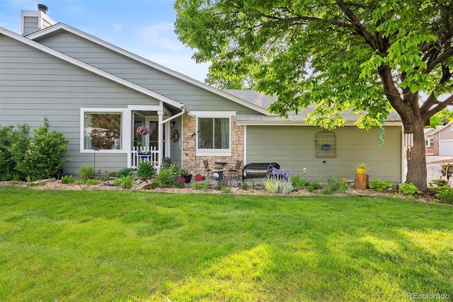 7 Shetland Ct, Highlands Ranch, CO 80130 - rear view of property featuring a yard, stone siding, and a chimney