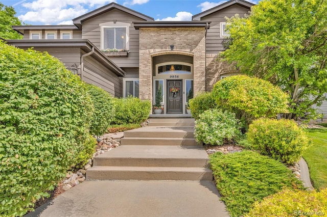 9856 Glenstone Trl, Highlands Ranch, CO 80130 - doorway to property featuring brick siding