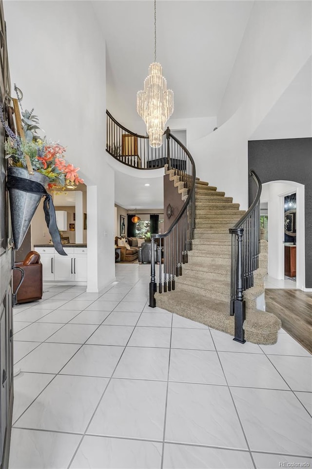 9856 Glenstone Trl, Highlands Ranch, CO 80130 - foyer entrance featuring stairs, a chandelier, a towering ceiling, and tile patterned floors