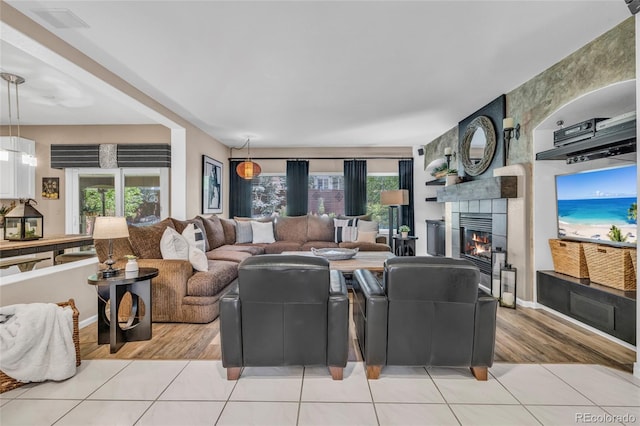 9856 Glenstone Trl, Highlands Ranch, CO 80130 - living room with light tile patterned floors, a fireplace, and plenty of natural light