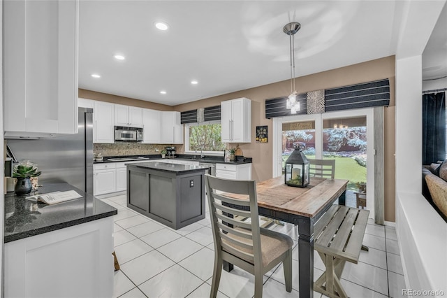 9856 Glenstone Trl, Highlands Ranch, CO 80130 - kitchen with appliances with stainless steel finishes, light tile patterned floors, white cabinetry, hanging light fixtures, and recessed lighting