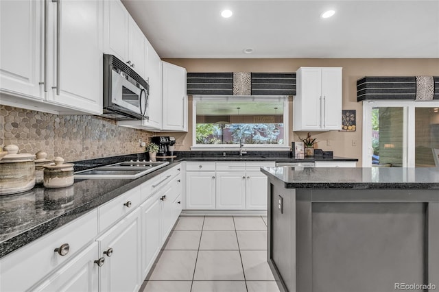 9856 Glenstone Trl, Highlands Ranch, CO 80130 - kitchen with stainless steel microwave, black electric cooktop, white cabinetry, and recessed lighting