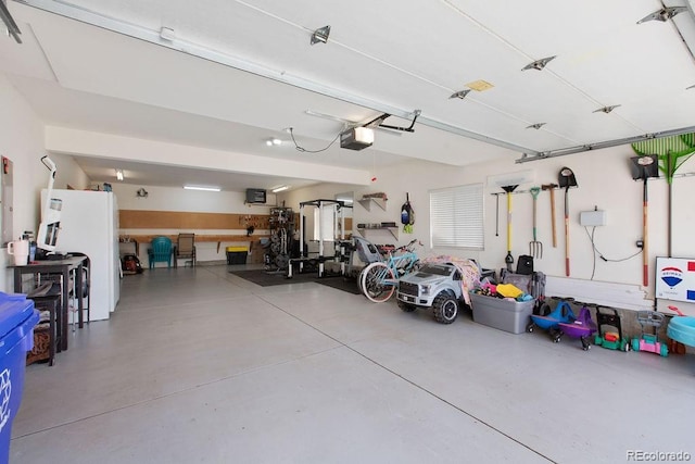 1275 W 50th St, Loveland, CO 80538 - garage featuring a garage door opener and freestanding refrigerator