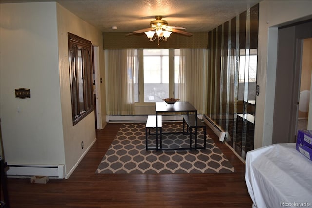 dining space featuring baseboards, baseboard heating, wood finished floors, and a ceiling fan