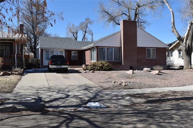 ranch-style home featuring crawl space, driveway, brick siding, and a chimney