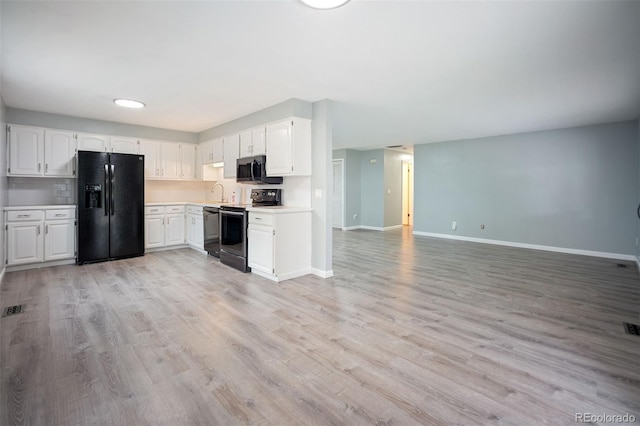 7659 S Holland Way, Littleton, CO 80128 - kitchen with stainless steel appliances, light countertops, light wood-style floors, and white cabinets