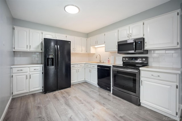 7659 S Holland Way, Littleton, CO 80128 - kitchen featuring black appliances, decorative backsplash, light wood-style flooring, light countertops, and white cabinetry