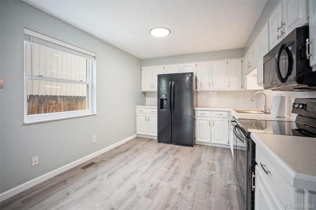 7659 S Holland Way, Littleton, CO 80128 - kitchen featuring black appliances, light wood-style flooring, white cabinets, and tasteful backsplash