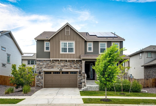 985 S Elk Way, Aurora, CO 80018 - craftsman-style house with board and batten siding, roof mounted solar panels, concrete driveway, an attached garage, and stone siding