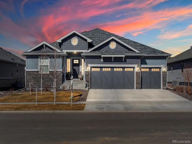 craftsman-style house featuring stone siding, concrete driveway, and an attached garage