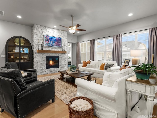 living room with wood finished floors, visible vents, a ceiling fan, a fireplace, and recessed lighting