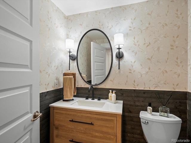 9035 S Shawnee Ct, Aurora, CO 80016 - half bath with wallpapered walls, vanity, toilet, and wainscoting