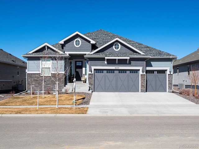 9035 S Shawnee Ct, Aurora, CO 80016 - craftsman house with stone siding, a garage, driveway, and central air condition unit