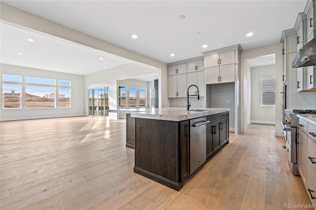 kitchen featuring a kitchen island with sink, sink, gray cabinets, and appliances with stainless steel finishes