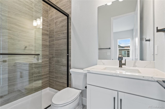 bathroom with walk in shower, vanity, and toilet