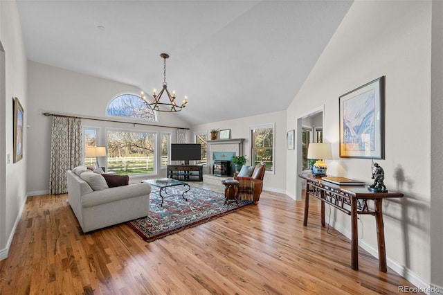 living room with hardwood / wood-style flooring, high vaulted ceiling, and a notable chandelier