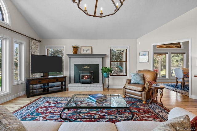 living room with vaulted ceiling, a notable chandelier, and light hardwood / wood-style floors