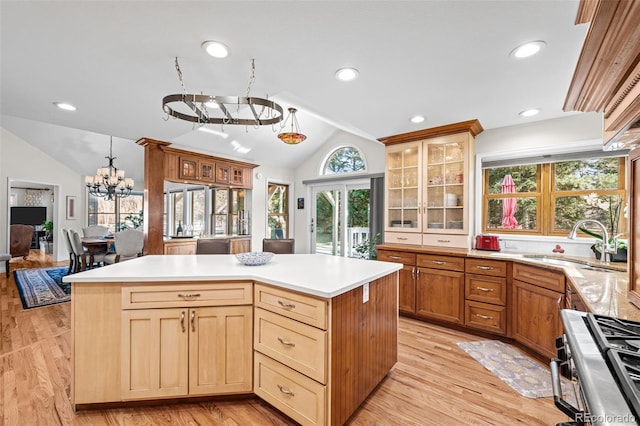 kitchen featuring lofted ceiling, a center island, sink, and stainless steel gas range oven