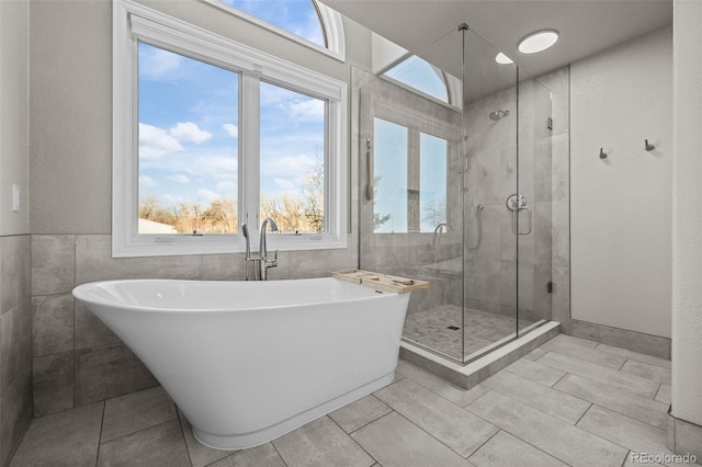 bathroom featuring tile patterned floors, independent shower and bath, and tile walls