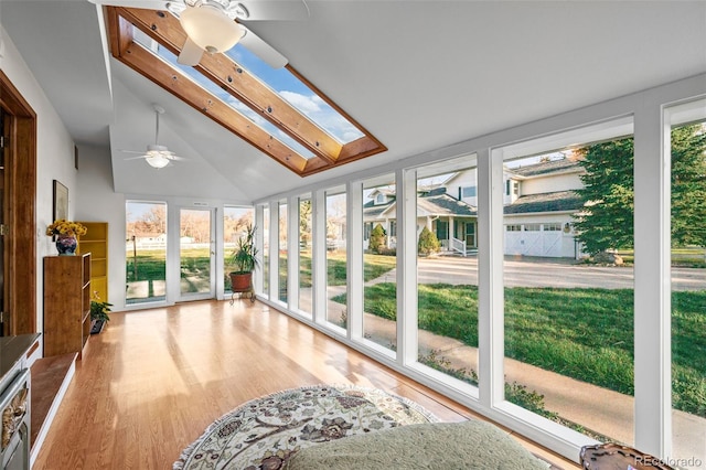 unfurnished sunroom with lofted ceiling with skylight, a healthy amount of sunlight, and ceiling fan