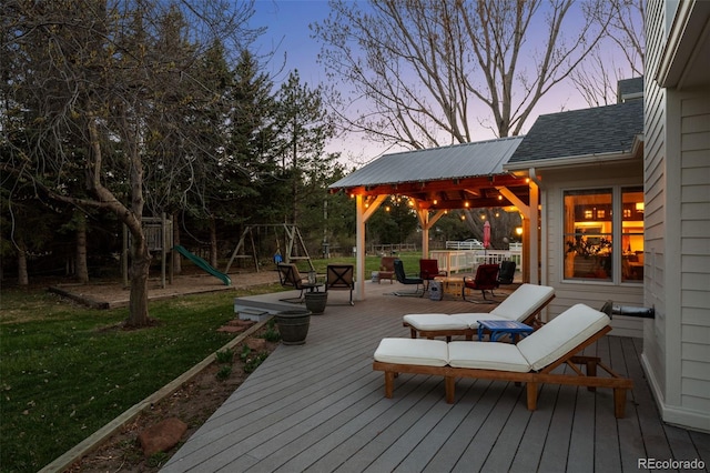 deck at dusk featuring a playground