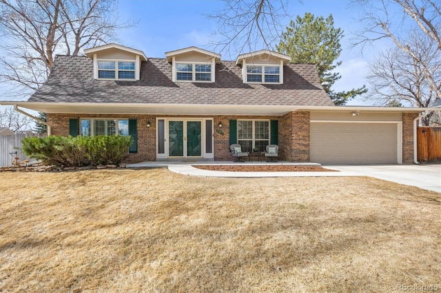 view of front of house featuring french doors, brick siding, roof with shingles, concrete driveway, and an attached garage