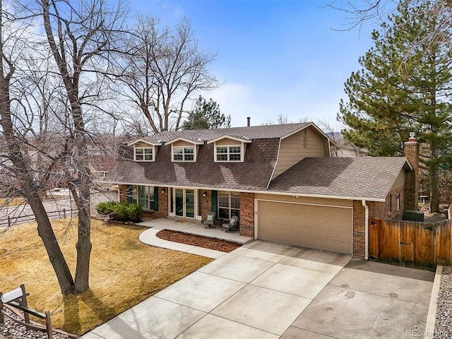 view of front of home with an attached garage, a shingled roof, brick siding, fence, and concrete driveway