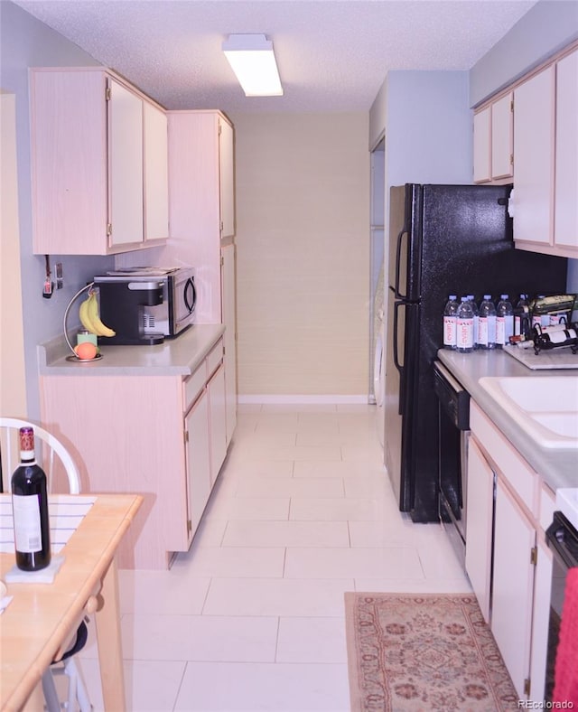 kitchen with black dishwasher, white cabinetry, stove, and a textured ceiling