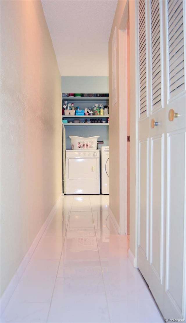 hall featuring washing machine and dryer and light tile patterned floors