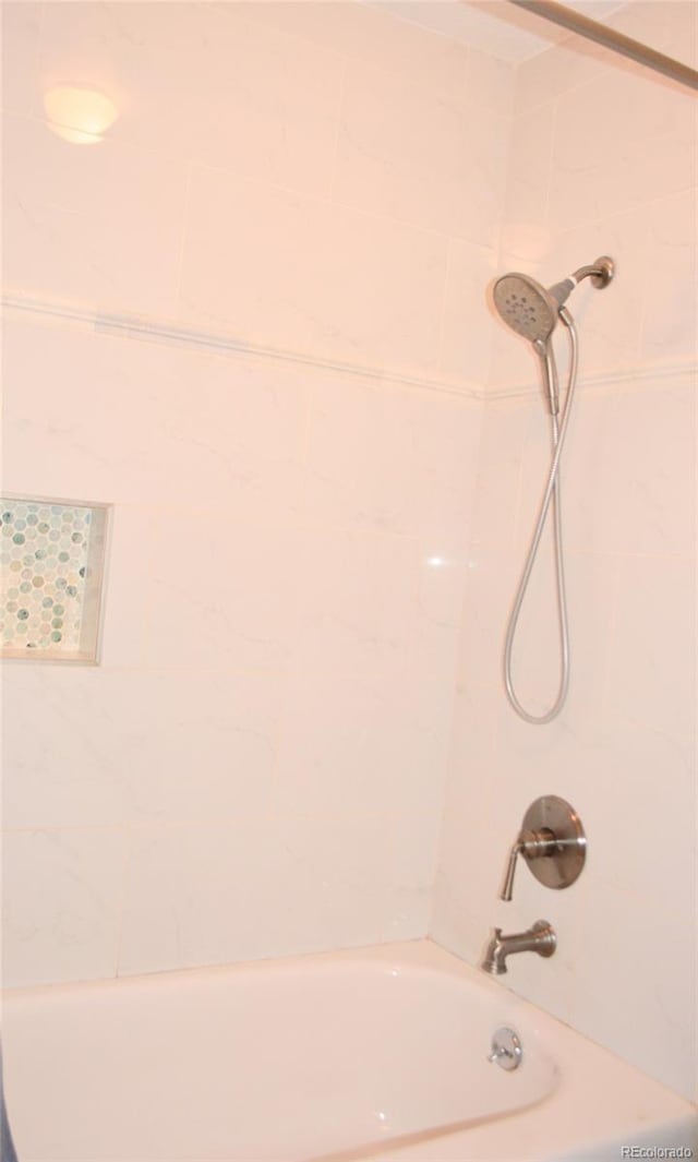 bathroom featuring tiled shower / bath