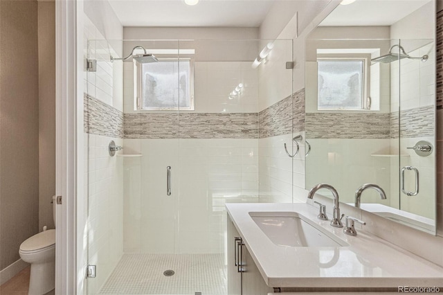 bathroom with vanity, a stall shower, and toilet