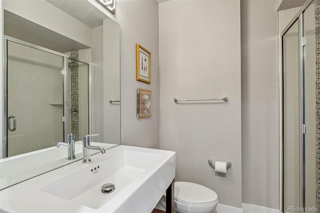 bathroom with a sink, a stall shower, and toilet