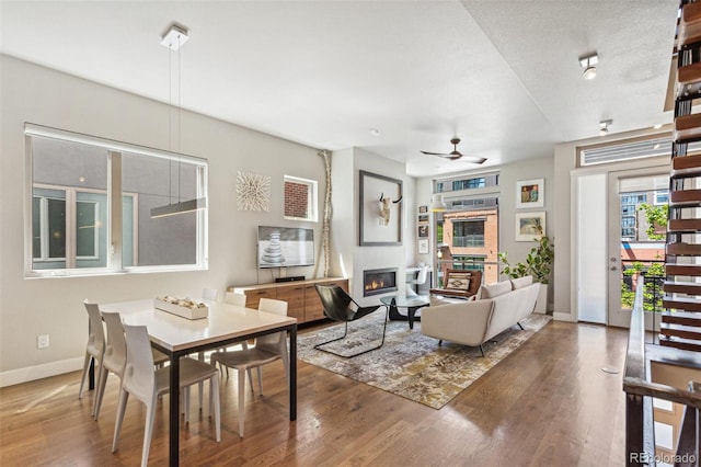 1012 Bannock St, Denver, CO 80204 - living area featuring a glass covered fireplace, wood finished floors, baseboards, and ceiling fan
