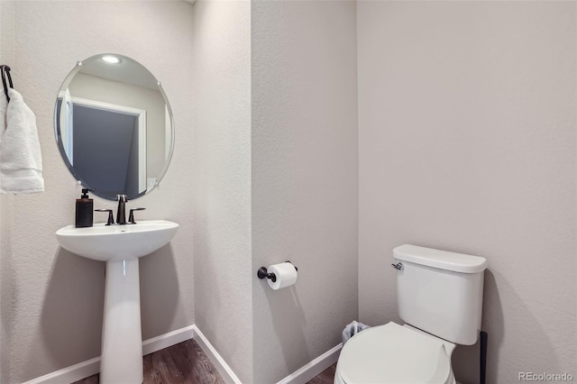 bathroom featuring toilet and wood-type flooring