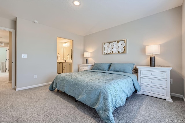 bedroom featuring ensuite bathroom and carpet floors