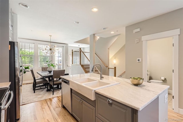 3411 N Xenia St, Denver, CO 80238 - kitchen with appliances with stainless steel finishes, light wood-style flooring, an island with sink, a chandelier, and recessed lighting